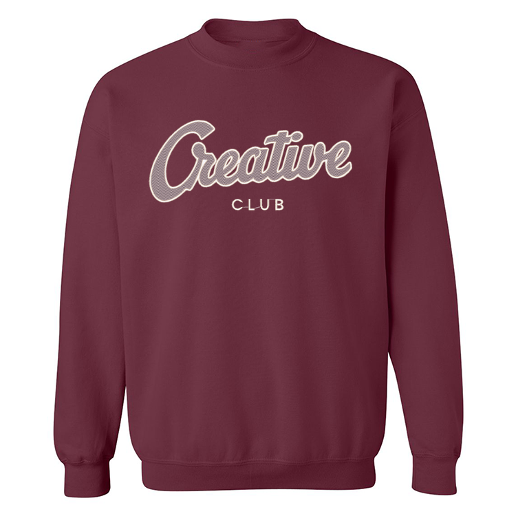 crewneck bourgogne ayant une grosse broderie grise foncée et blanche creative club