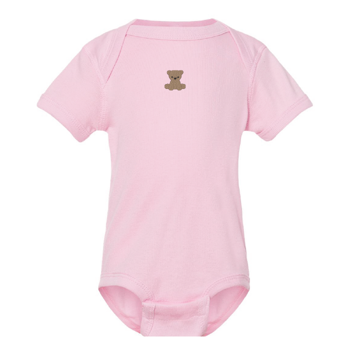 cache-couche rose pâle brodé avec un petit ourson au centre