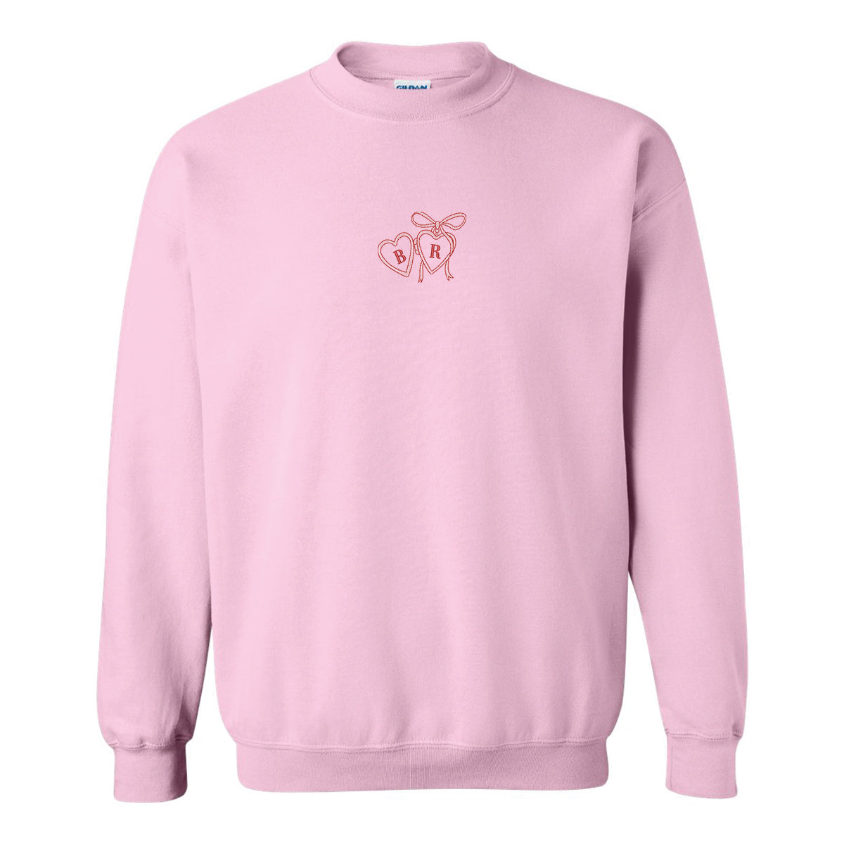 coton ouaté à col rond rose pâle sur fond blanc avec broderie de pendentif en forme de coeur rose et rouge ayant des initiales brodées
