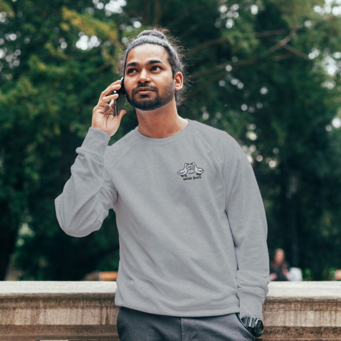 photo lifestyle homme aux cheveux longs portant un crewneck gris pâle goose bumps avec des oies brodées