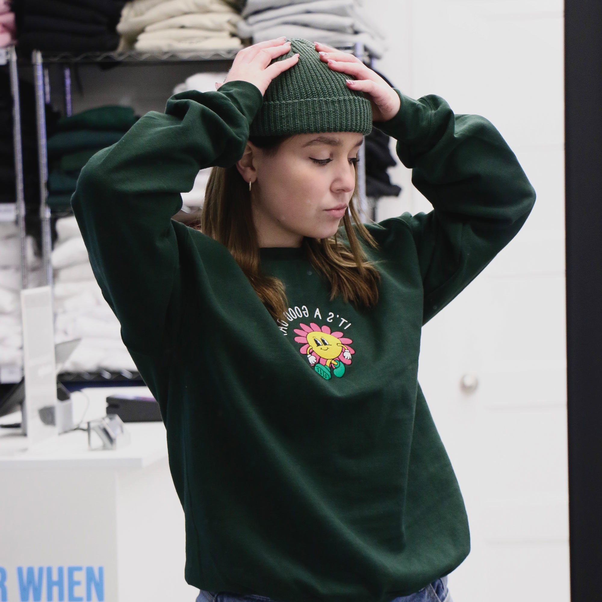 photo d'une jeune femme blonde portant un crewneck vert foret brodame X Oska