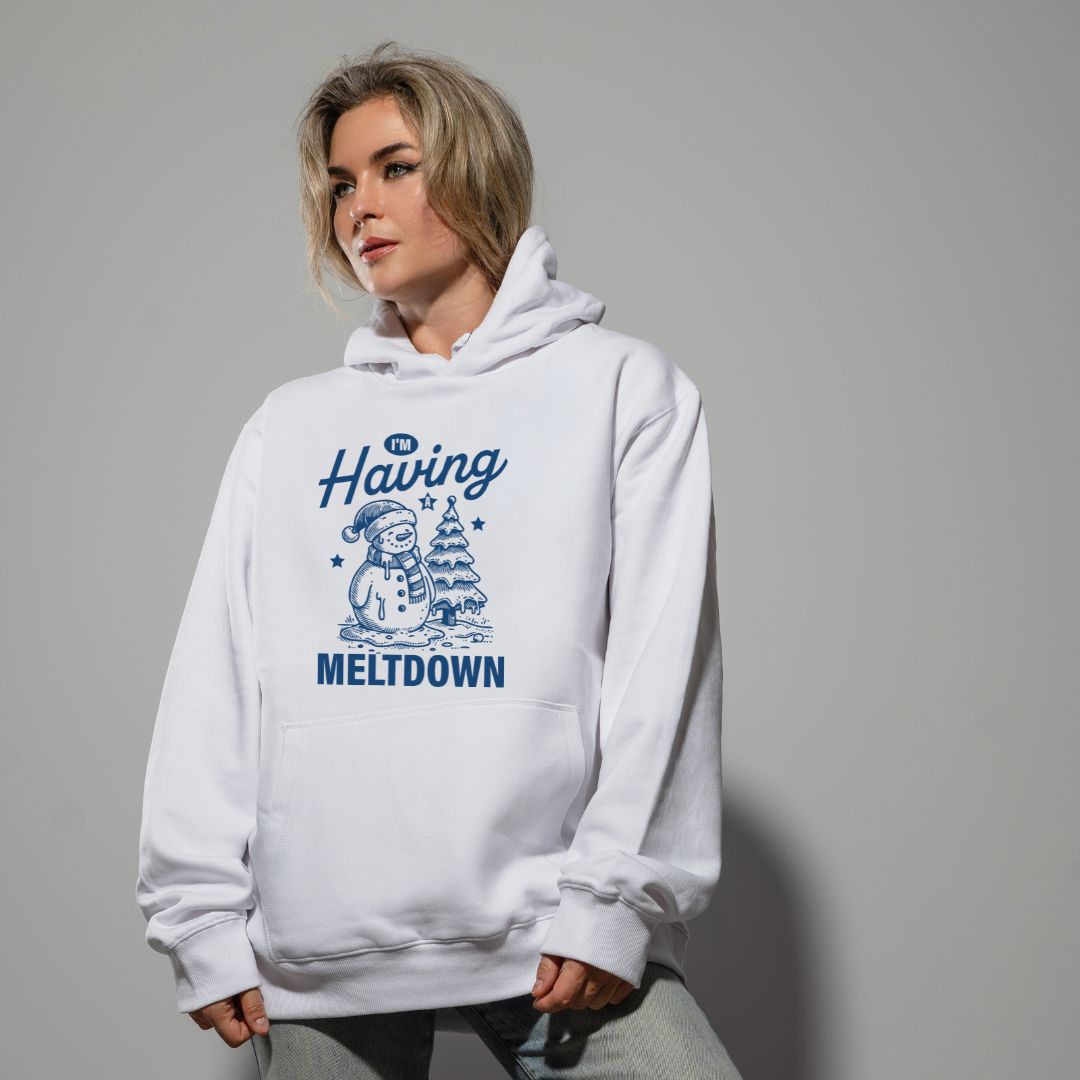 photo lifestyle d'une femme blonde portant un coton ouaté à capuchon blanc avec un imprimé de sapin et de bonhomme de neige qui fond et la phrase "I'm having a meltdown"