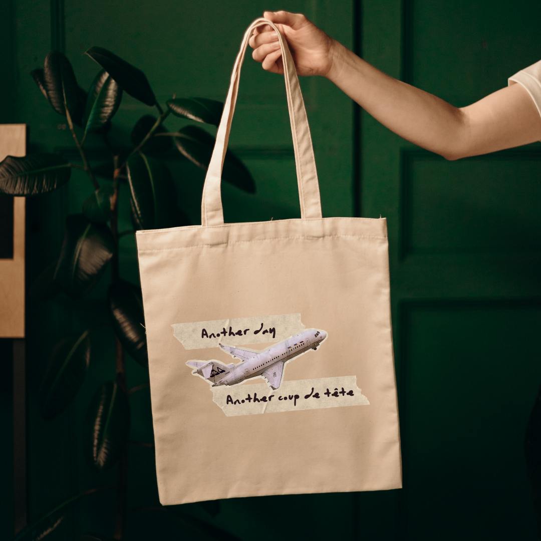 photo d'une femme dans un studio de photographie tenant un sac fourre-tout beige avec une impression d'avoir et une phrase humoristique