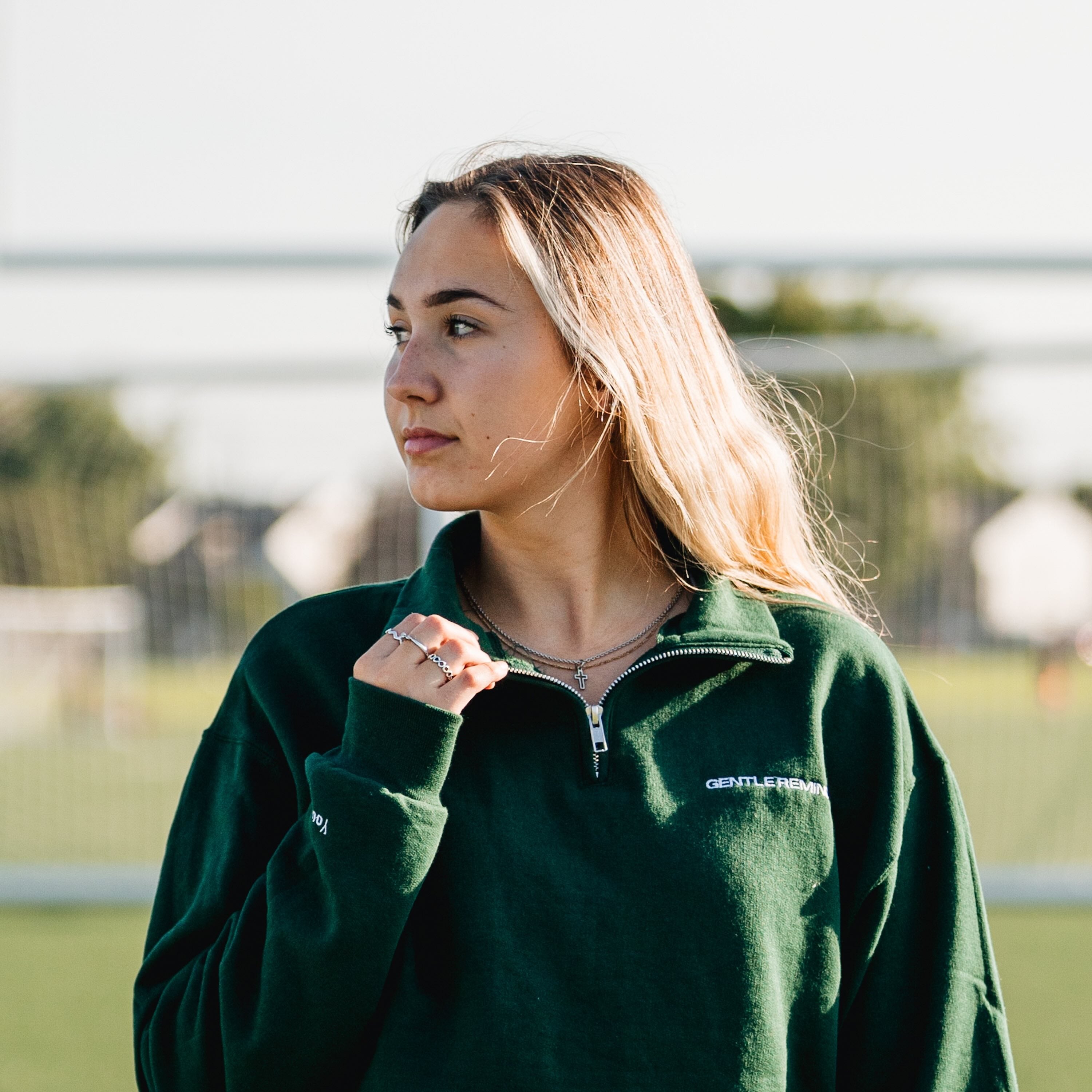 fille qui regarde au loin avec un 3 quart zip vert forest de la collection college de brodame