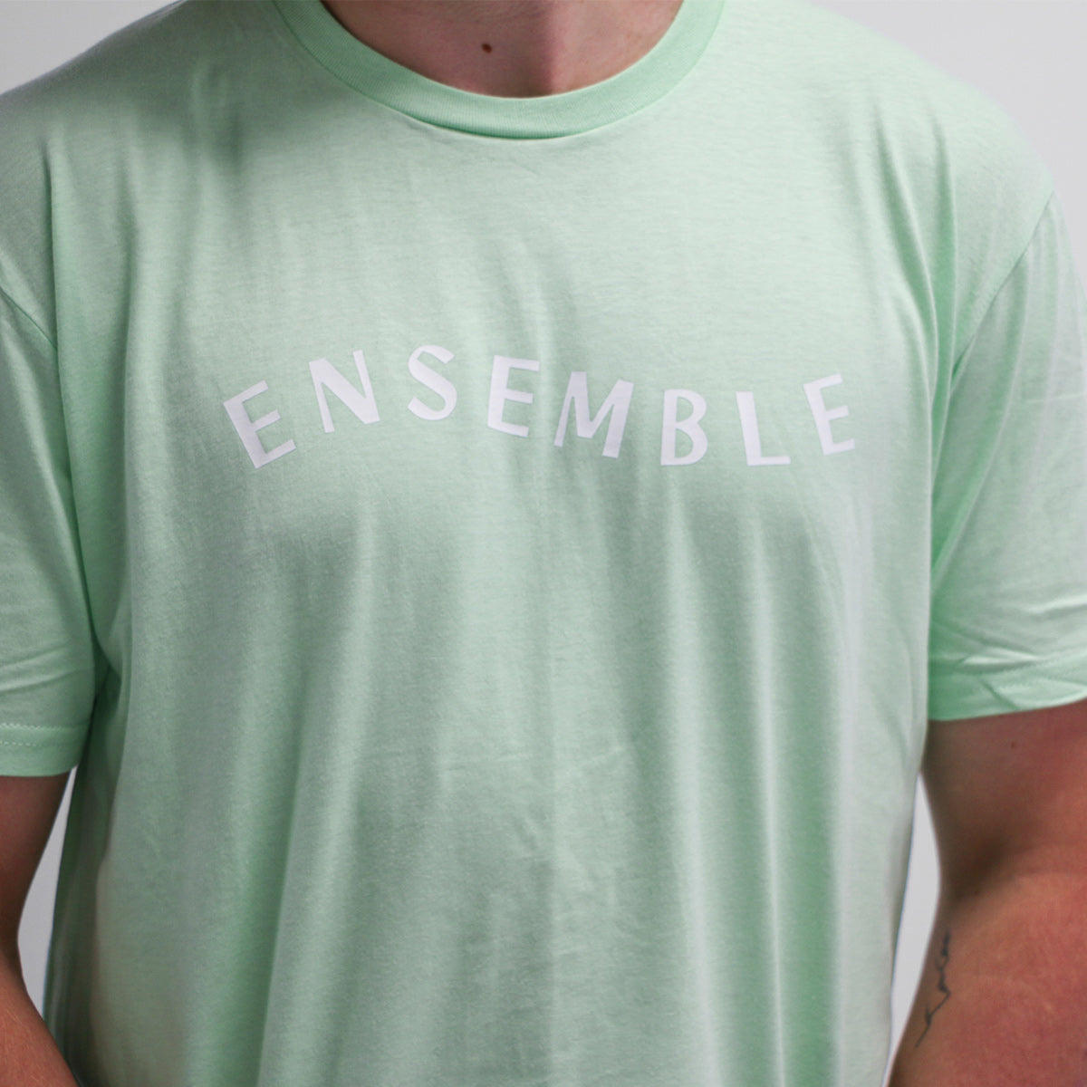 plan rapproché du t-shirt menthe avec une imprimé menthe très pâle "ensemble" en centre