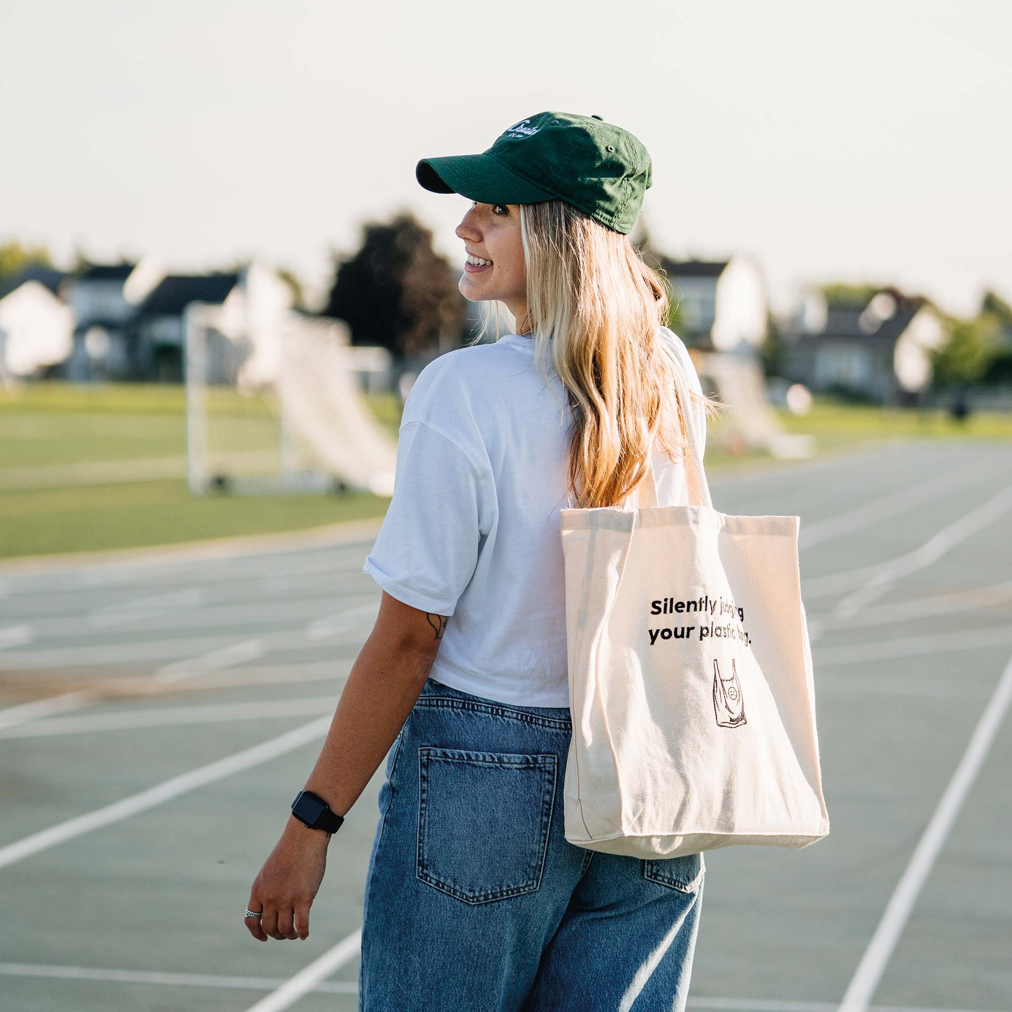 belle fille portant un tote bag beige et une casquette creative club vert forest de chez brodame