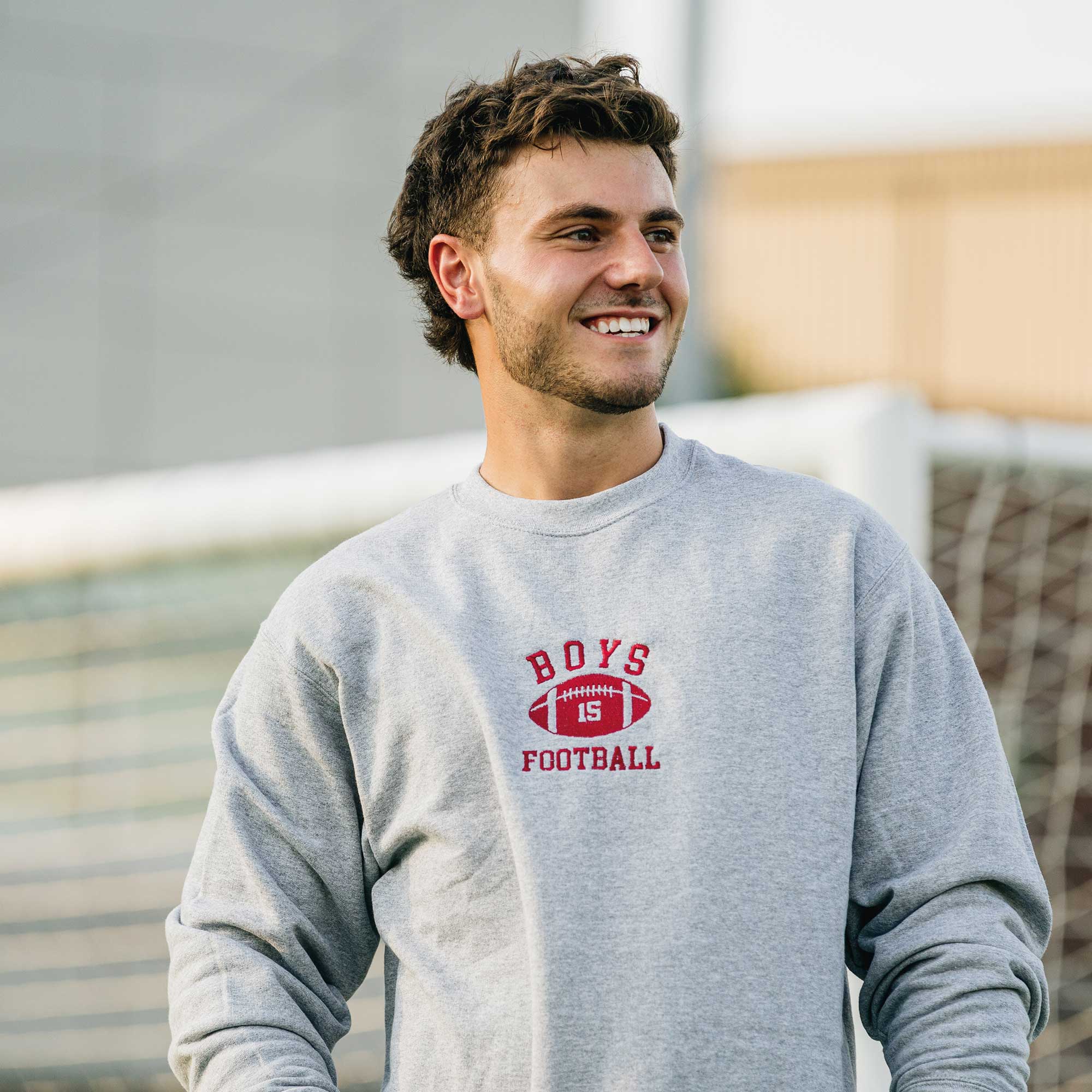 un homme heureux qui porte un crewneck de la collection college de brodame