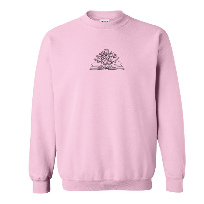 crewneck rose pâle brodé avec un livre et des fleurs minimalistes