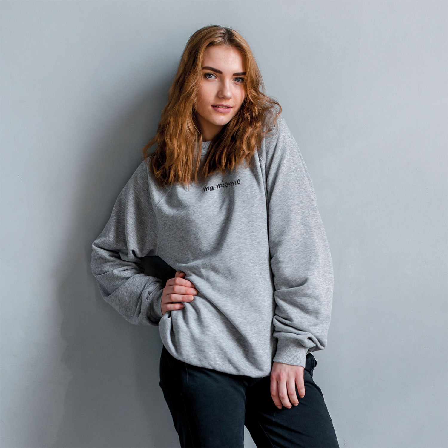 photo lifestyle d'une jeune femme portant uncrewneck gris pâle brodé "mon mien" en noir