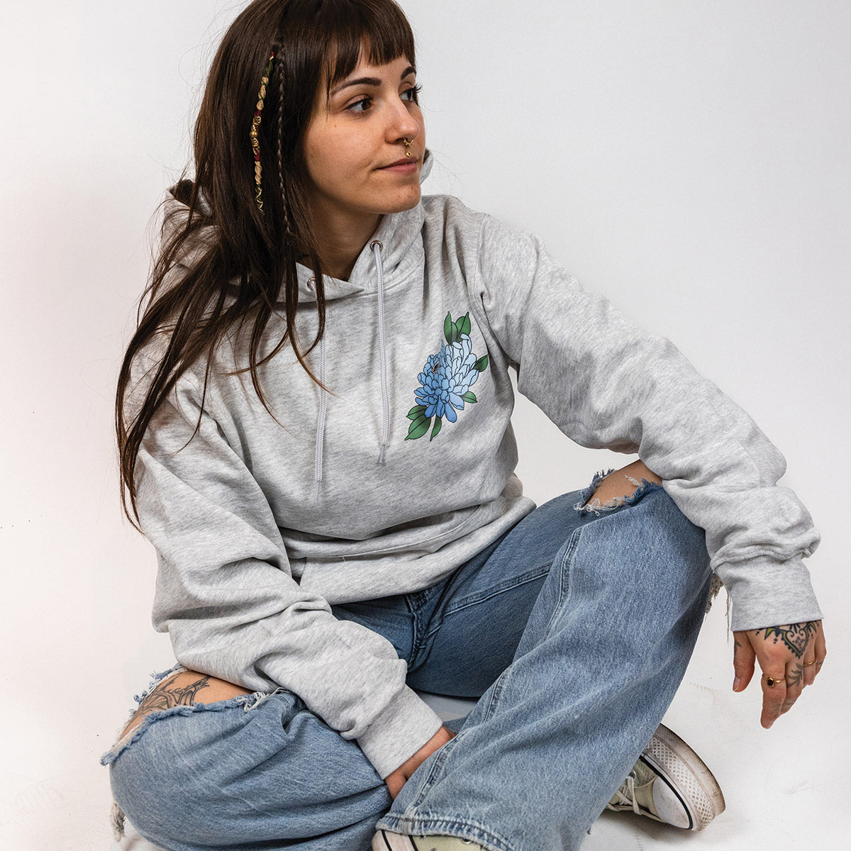 jeune femme portant un coton ouaté à capuchon gris cendré avec un imprimé de fleur bleue au coeur