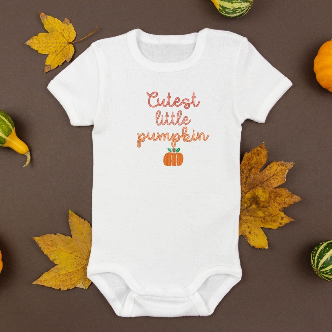 photo de cache-couche blanc pour bébé avec une broderie de petite citrouille orange