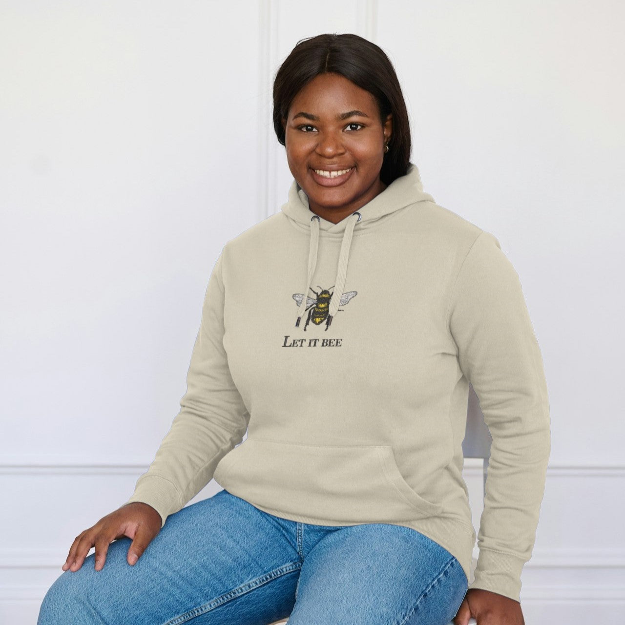 photo d'une jeune femme afroamericaine portant le hoodie beige let it bee brodé avec une abeille