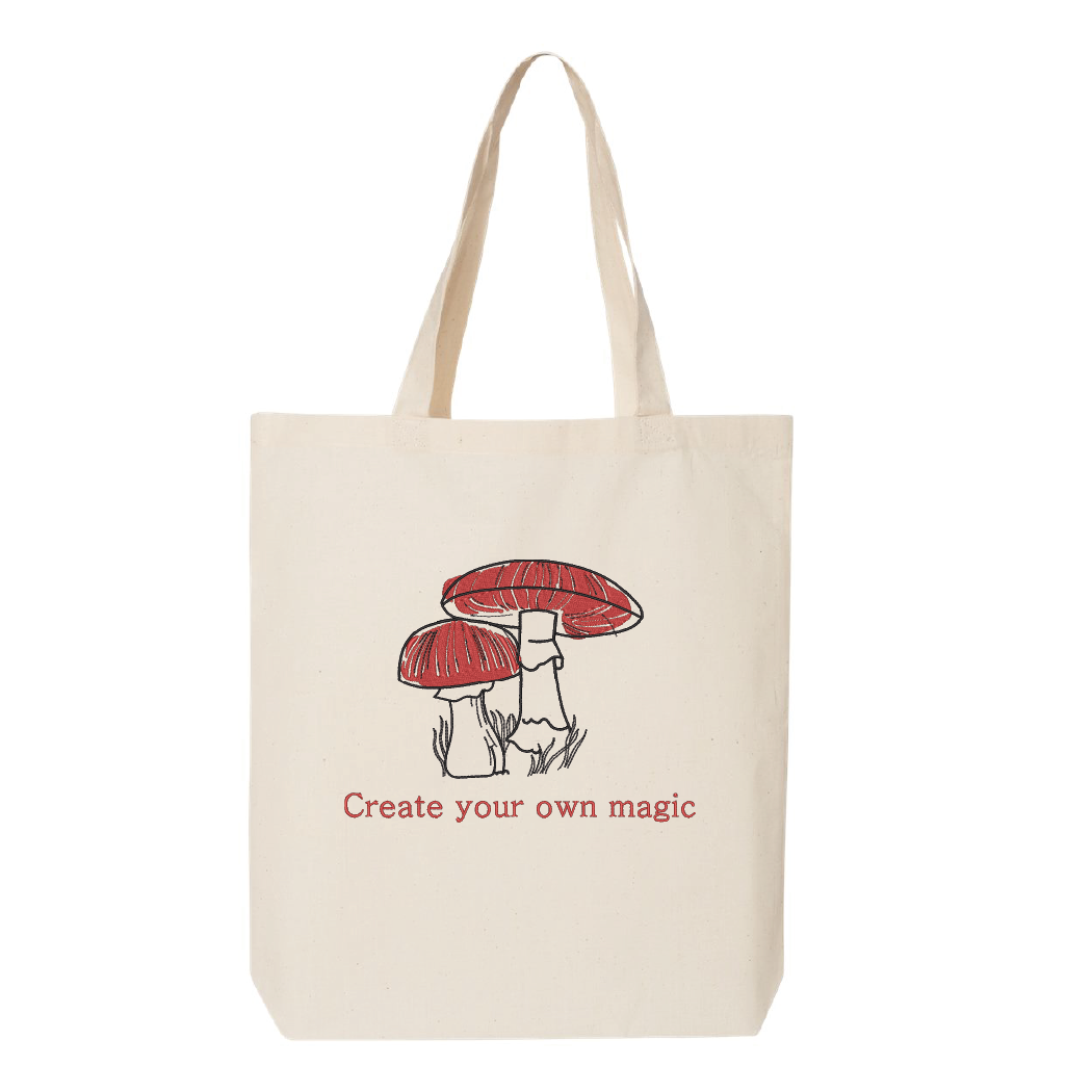 sac fourre-tout beige brodé avec des champignons rouges et noire avec la citation create your own magic